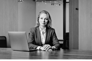 Founder of Bellastrega Media & Design seated at a desk, representing service driven leadership and intentional growth